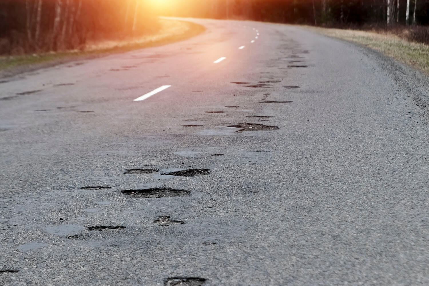The,Road,In,Disrepair,With,A,Lot,Of,Potholes.,Cars